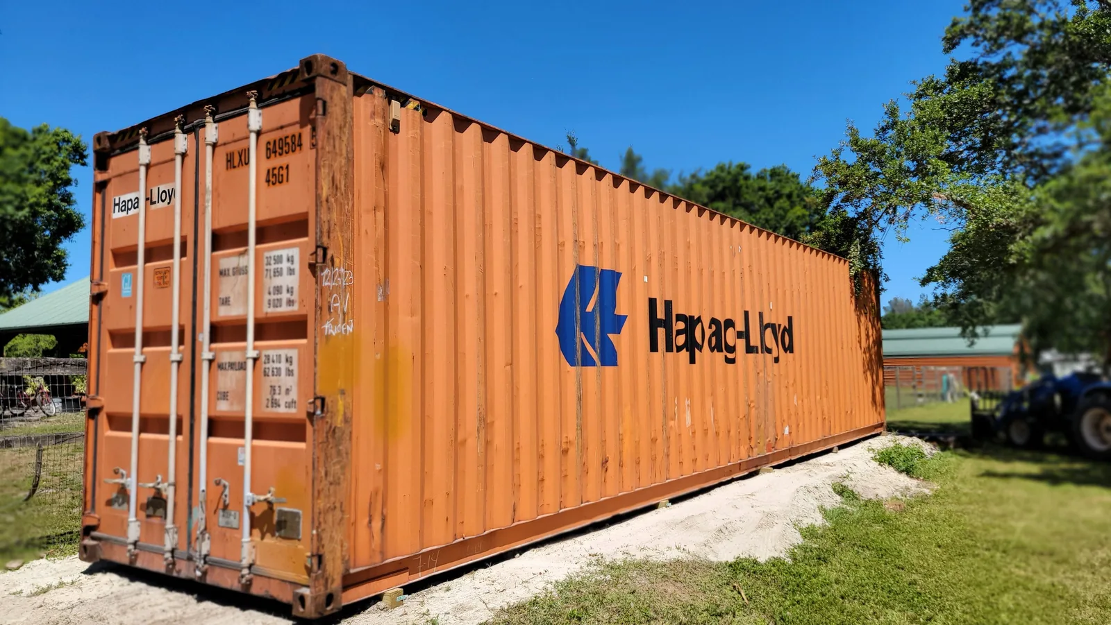Orange used 40-foot shipping container placed outdoors.