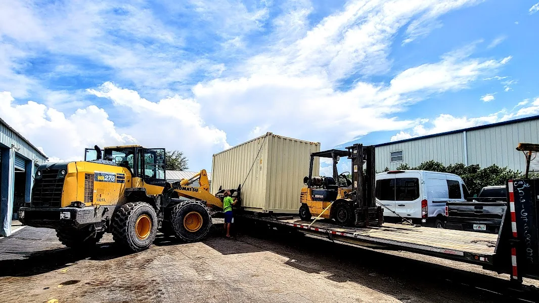 Shipping container, lifting equipment and delivery truck at the fabrication yard.