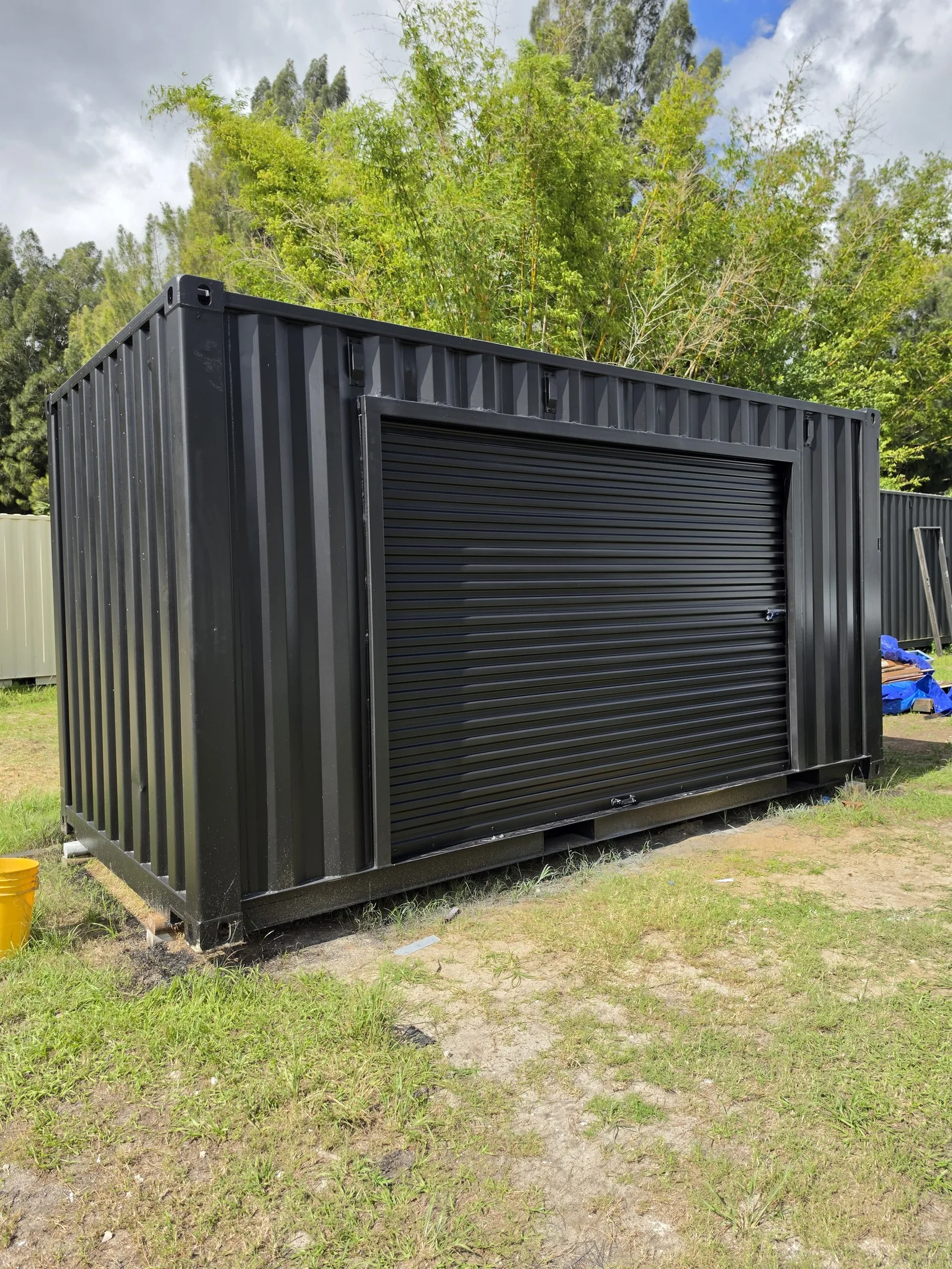 Black custom 16-foot container with a wide roll-up door.